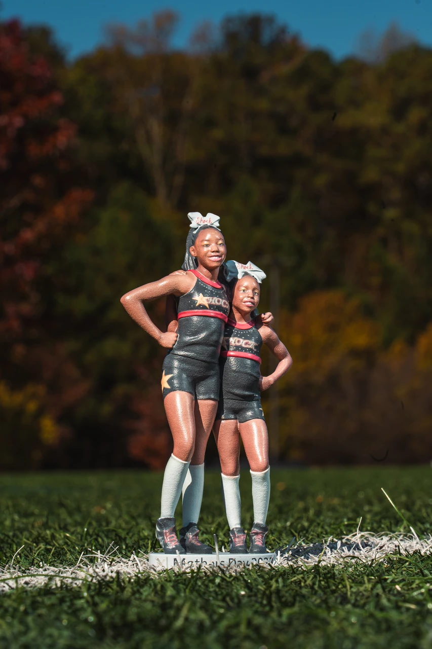 3D-printed figurines of two cheerleaders on a custom Mother's Day base